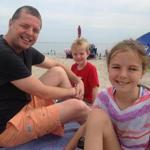 Andrew Collins on the beach with his kids.
